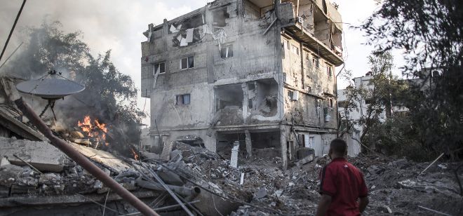 Un palestino observa un edificio destruido durante el bombardeo nocturno.
