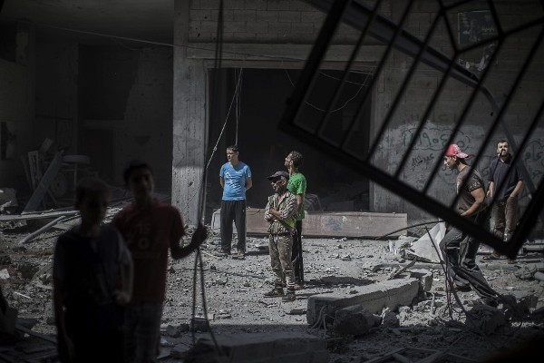 Varios curiosos revisan los daños registrados en un edificio poco después de un ataque aéreo del Ejército israelí en la ciudad de Gaza, franja de Gaza, hoy, jueves 17 de julio de 2014.