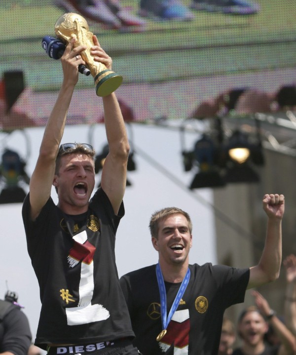 2014. El jugador alemán, Thomas Müller (i), levantando la Copa del Mundo por encima de su cabeza, y Philipp Lahm (d), celebran su victoria en el Mundial, en el lamado 