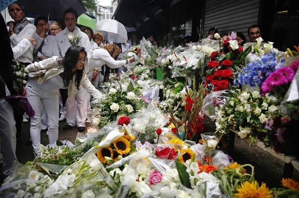 Varias personas dejan ramos de flores en honor de los dueños del restaurante Asian Glories, quienes murieron en el siniestro del avión MH17 de Malaysian Airlines, durante un memorial hoy, lunes 21 de julio de 2014, en Róterdam (Holanda). 