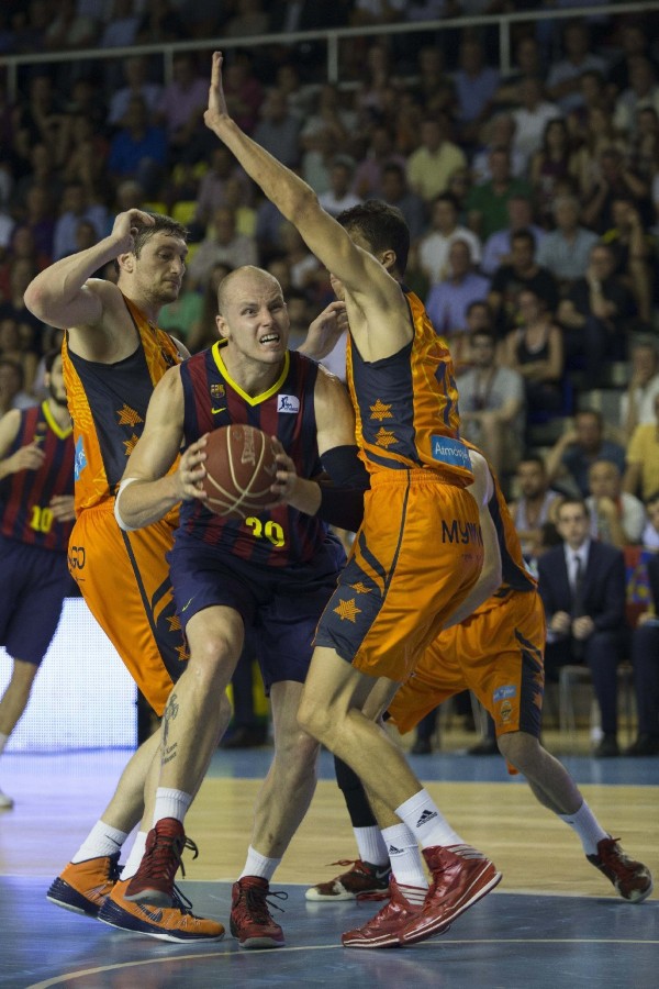 El pívot polaco del FC Barcelona, Maciej Lampe (c), entre el pívot ucraniano del Valencia Basket, Serguei Lishchuk (i), y el alero serbio, Vladimir Lucic (d) durante el tercer partido de las semifinales de la Liga ACB, disputado en el Palau Blaugrana.