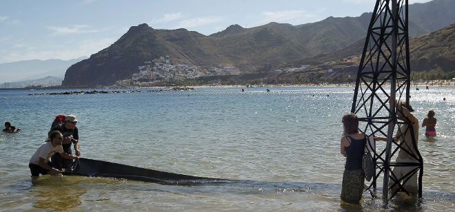 Activistas de la organización ecologista Greenpeace escenificaron en la playa de Las Teresitas los efectos que tendría una marea negra.