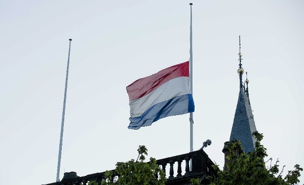 Vista de la bandera de Holanda a media asta en el edificio del Parlamento en La Haya. El país espera los primeros restos de las víctimas holandesas del hecho, procedentes de Ucrania.