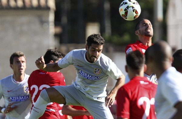 El centrocampista del Atlético de Madrid Raúl García cabecea el balón durante el partido amistoso correspondiente al II Memorial Jesús Gil, que disputan frente al Numancia en el campo municipal de El Burgo de Osma (Soria).