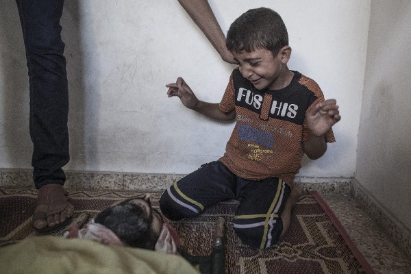 Un niño llora ante el cadáver de un familiar muerto en el bombardeo a una escuela de la ONU reconvertida en centro de acogida para desplazados en Jabalia, en el norte de la franja de Gaza, hoy, miércoles 30 de julio de 2014. 
