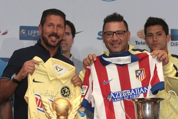 El director técnico del Atlético de Madrid, el argentino Diego Simeone (i), y su par del América mexicano, Antonio Mohamed (c), posan durante una rueda de prensa.