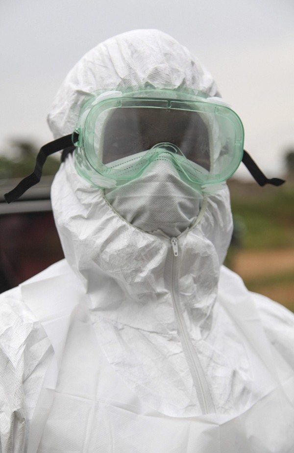Fotografía facilitada hoy, jueves 7 de agosto de 2014 que muestra a un enfermero liberiano mientras trabaja en la retirada y entierro de una víctima del ébola en la comunidad de Virginia, a las afueras de Monrovia (Liberia) ayer.