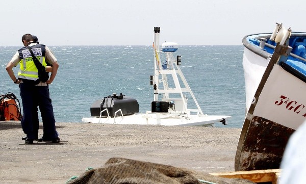 Agentes de la Policía Científica junto al barco en el que se hicieron a la mar los dos submarinistas que fallecieron mientras realizaban una inspección a unos criaderos de peces en la zona de El Berriel, en el municipio de San Bartolomé de Tirajana, al sur de la isla de Gran Canaria.