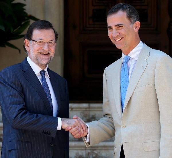 El presidente del Gobierno, Mariano Rajoy (i), y el Rey estrechan las manos esta mañana, en el primer despacho que celebra con el Monarca en el Palacio de Marivent, la residencia de verano de la Familia Real. 