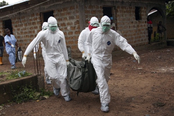 Fotografía facilitada el viernes 8 de agosto de 2014 en la que aparecen unos enfermeros liberianos con equipos de protección individual que trasladan el cuerpo de una víctima del ébola para su entierro en la comunidad de Banjor, a las afueras de Monrovia (Liberia).