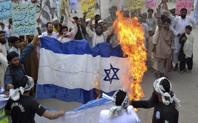 Pakistaníes prenden fuego a una bandera israelí.