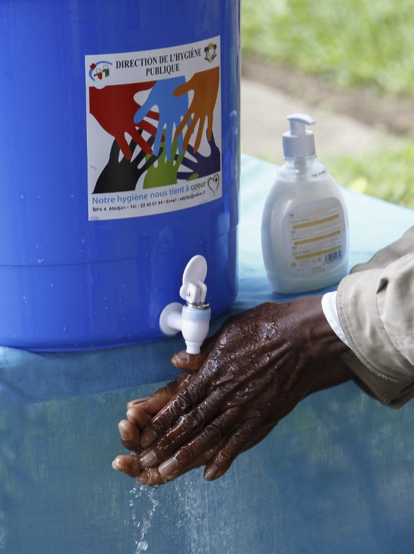Un hombre se lava las manos a su salida de un institución pública en Costa de Marfil.