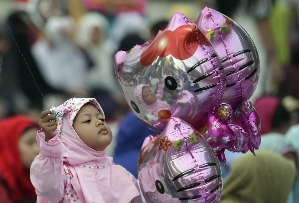 Una niña con un globo caracterizado como Hello Kitty.