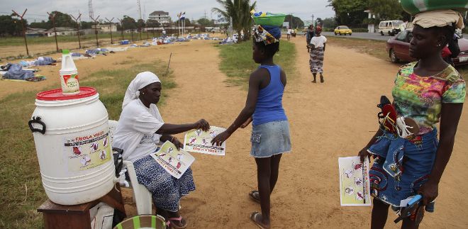 Una mujer liberiana de la Red de Mujeres para la Construcción de la Paz informa sobre el virus del ébola a otras mujeres en un campamento de WIPNET en Liberia.