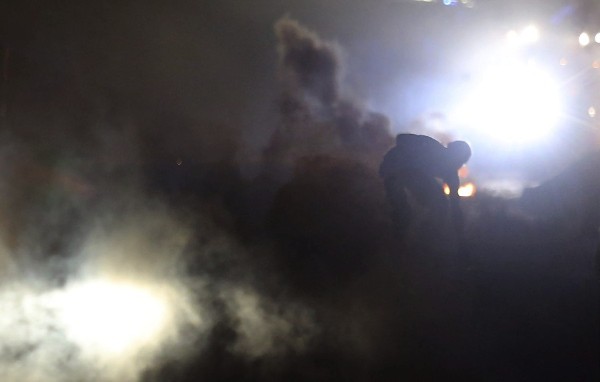 Un manifestante aparece entre el humo durante una protesta por la muerte de Michael Brown en Ferguson (Estados Unidos) ayer, domingo 17 de agosto de 2014. 