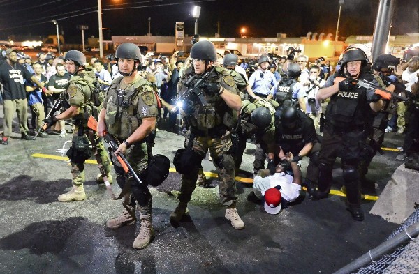 Policías arrestan a manifestantes mientras continúan las protestas contra la muerte del joven Michael Brown en Ferguson.