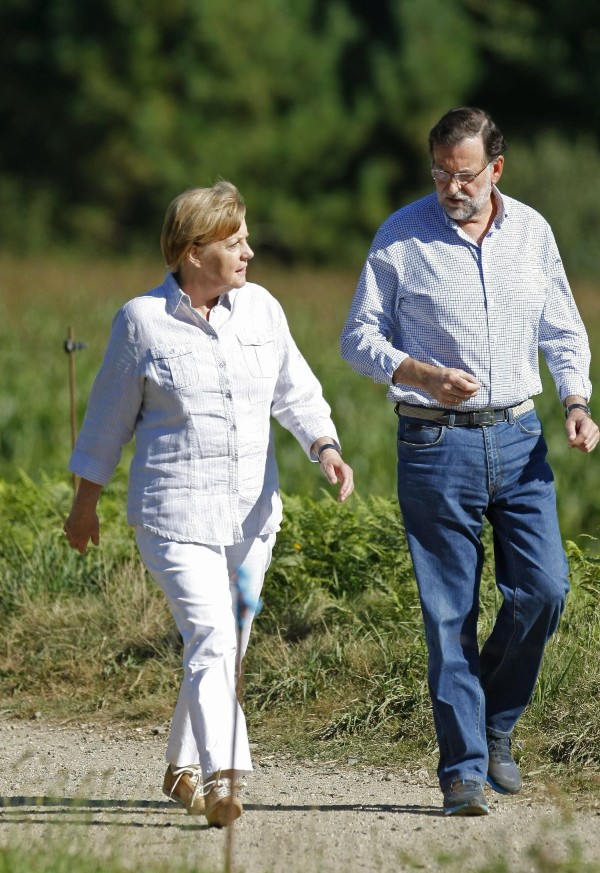 El presidente del Gobierno, Mariano Rajoy (d), y la canciller alemana, Angela Merkel (i), recorren a pie un tramo del Camino de Santiago, en el municipio de O Pino (A Coruña) cerca de Santiago de Compostela.