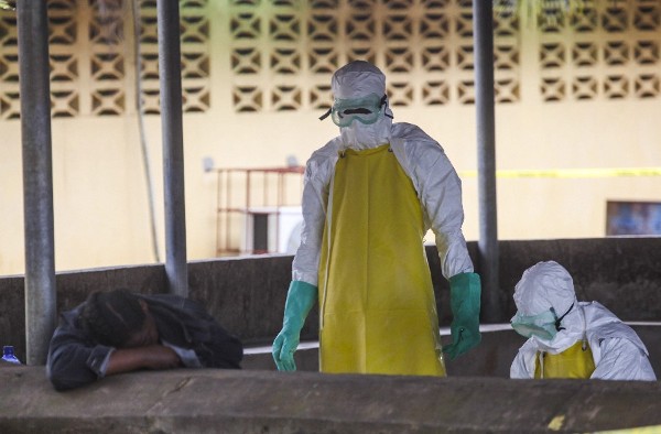 Trabajadores de salud liberianos se preparan para recoger el cuerpo de una víctima del ébola del área de espera de un hospital en Monrovia (Liberia) el martes 26 de agosto de 2014. 