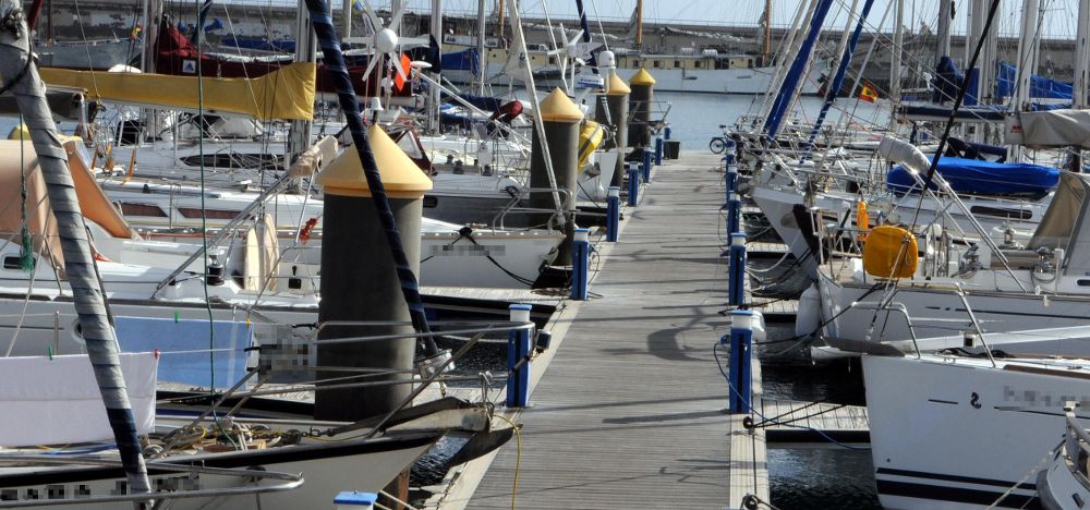 La imagen muestra un grupo de naves amarradas a un pantalán de una de las marinas que existen en Tenerife .
