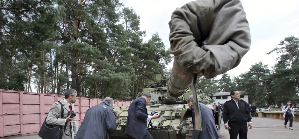 Observadores militares internacionales observan un tanque supuestamente fabricado en Rusia.