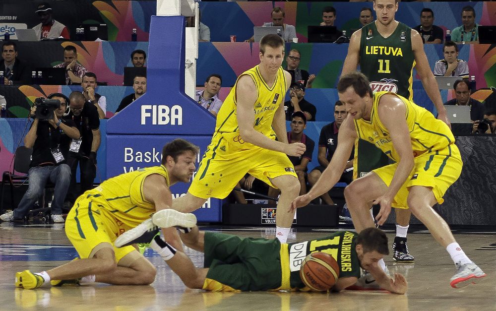 El base lituano Sarunas Vasiliauskas (c) lucha un balón con varios jugadores australianos.