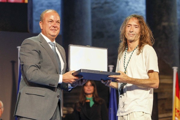 El rockero placentino Robe Iniesta (d), líder del grupo Extremoduro, recibe la Medalla de Extremadura 2014 de manos del presidente extremeño, José Antonio Monago, durante la celebración del Día de Extremadura, la pasada noche, en el Teatro Romano de Mérida.