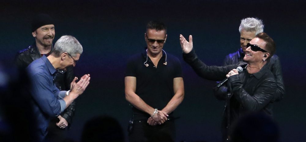 Bono (d), de la banda irlandesa U2, presenta al director ejecutivo de Apple, Tim Cook (i), durante el evento de lanzamiento de dispositivos Apple en el Centro Flint de Artes Escénicas en Cupertino, California (EE.UU.) hoy, martes 9 de septiembre de 2014. El Centro Flint fue el lugar en el que Steve Jobs lanzó el primer computador Apple Macintosh en 1984.
