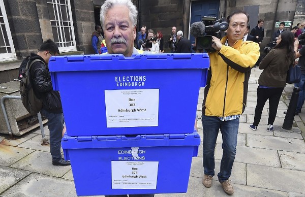 Un operario carga las urnas electorales en un camión.