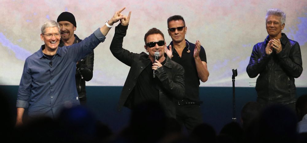 Bono (c), de la banda irlandesa U2, levanta la mano al director ejecutivo de Apple, Tim Cook (i), durante el evento de lanzamiento de dispositivos Apple en el Centro Flint de Artes Escénicas en Cupertino, California (EE.UU.).