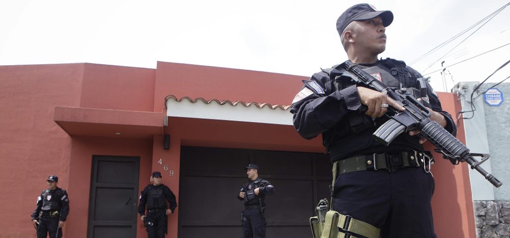 Agentes de la Unidad de Mantenimiento del Orden de la Policía Nacional Civil vigilan la casa del expresidente salvadoreño Francisco Flores.