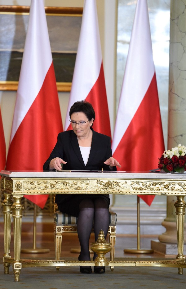 La nueva primera ministra, Ewa Kopacz (c), firma los documentos tras prestar juramento del cargo en el Palacio Presidencial en Varsovia (Polonia) hoy lunes 22 de septiembre de 2014. 