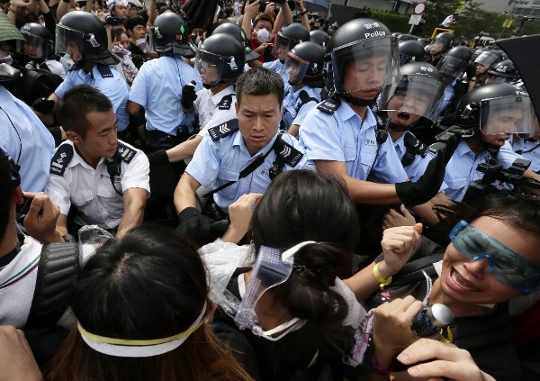 Agentes de la policía contienen a los manifestantes que bloquean el acceso a edificios gubernamentales.