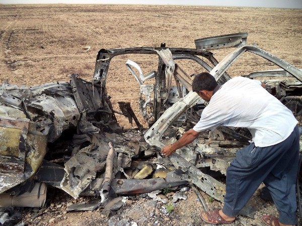 Un iraquí inspecciona un camión destruido usado por integrantes del grupo Estado Islámico.