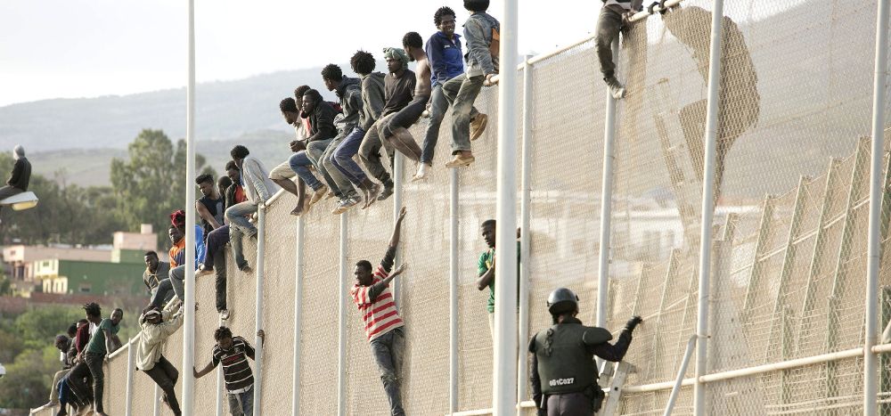 En torno a un centenar de inmigrantes permanecen encaramados en la valla fronteriza entre Melilla y Marruecos.