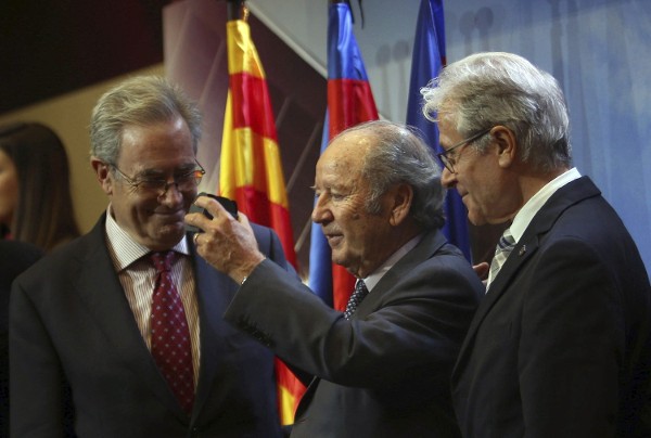 El expresidente Josep Lluís Núñez (c) muestra la insignia de oro de los 25 años de la asociación de veteranos, durante el homenaje ofrecido a los jugadores supervivientes que vistieron la zamarra azulgrana en los años 40, así como a los que formaron parte del equipo de las 'Cinco Copas', en un emotivo acto impulsado por la Agrupació Barça Jugadors.