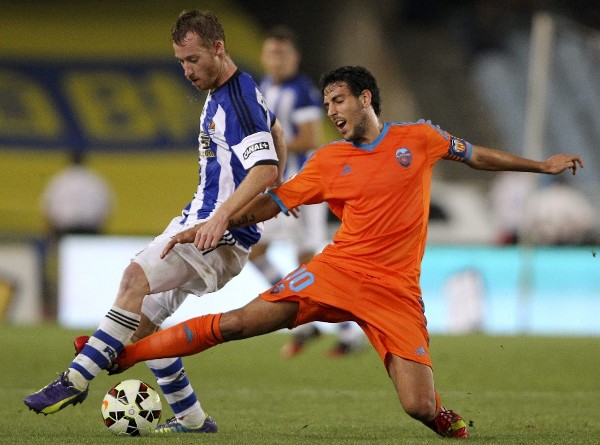 El centrocampista de la Real Sociedad David Zurutuza (i) lucha un balón con el centrocampista del Valencia Daniel Parejo.