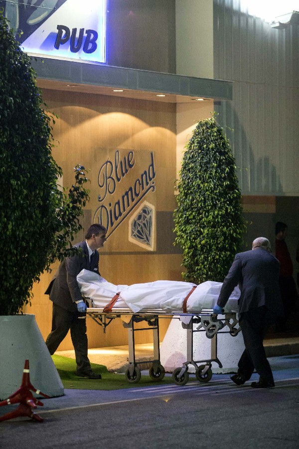 Dos trabajadores de la funeraria trasladan los cuerpos de las dos personas que han fallecido hoy por heridas de arma de fuego, en el disco-pub 
