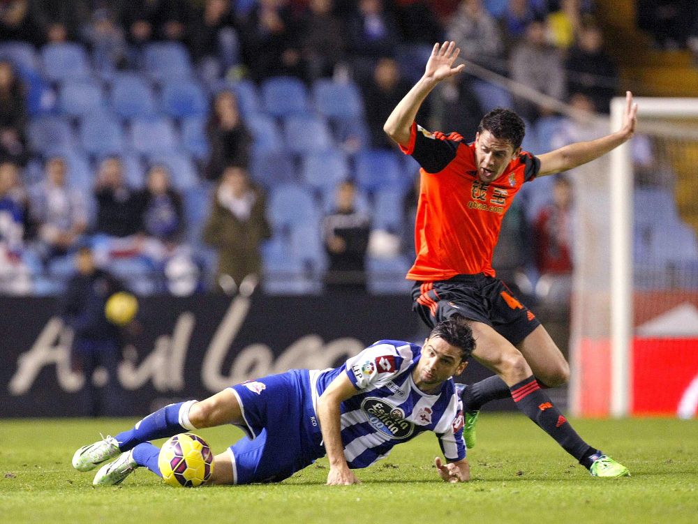 El defensa de la Real Elustondo (d) lucha el balón con Helder Postiga, del Deportivo.