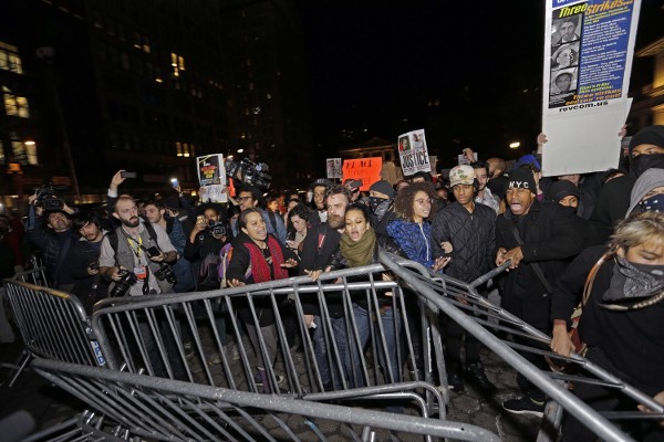 Cientos de manifestantes saltan las vallas instalada en Union Square, en Nueva York, este 24 de noviembre de 2014, luego de darse a conocer que el policía que mató al joven afroamericano Michael Brown en Ferguson no será imputado.