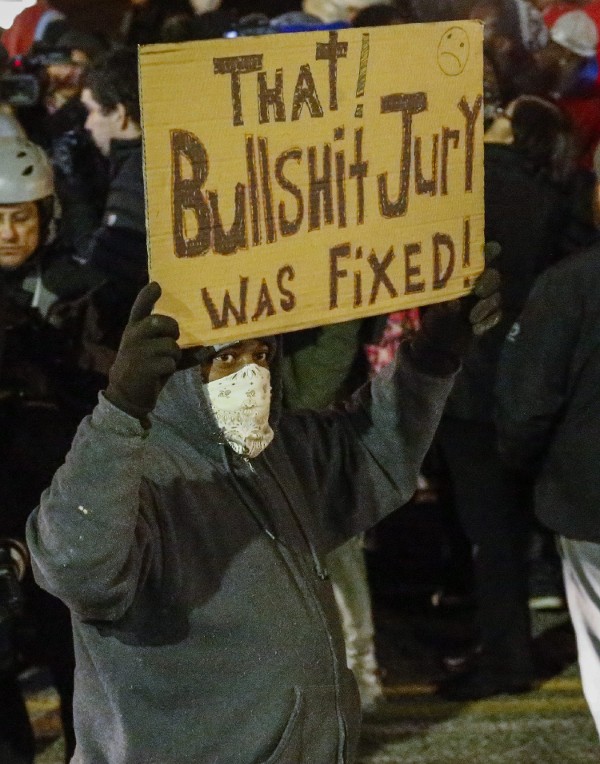 Un manifestante levanta una pancarta en contra del fallo del jurado en el caso de la muerte de Michael Brown.