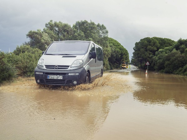 Un vehículo atraviesa la calzada inundada en la carretera A-408 a la altura de Puerto Real (Cádiz).