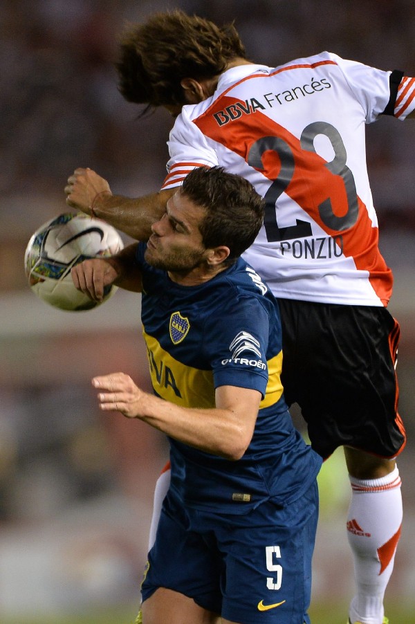 Leonardo Ponzio de River Plate disputa el balón con Fernando Gago de Boca Juniors .