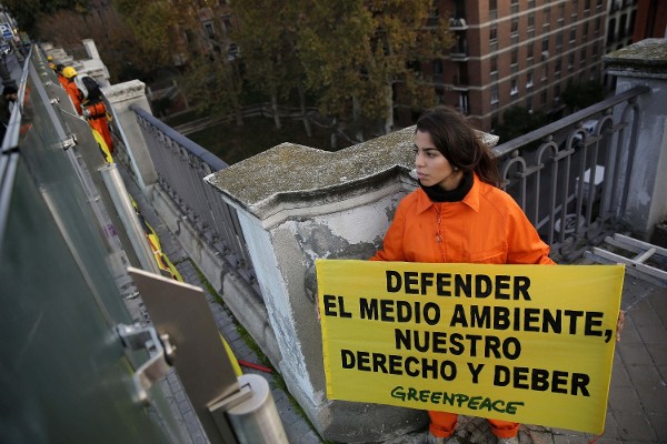 Fotografía facilitada por Greenpeace de una activista que forma parte de la organización ecologista Greenpeace, y que ha desplegado esta mañana en el Viaducto de la calle Bailén de Madrid una pancarta de 126 metros cuadrados para protestar por las medidas 