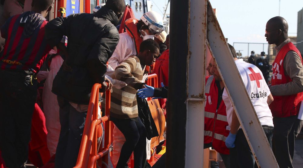 Varios de los 26 inmigrantes rescatados de la patera localizada hoy en aguas del mar de Alborán a su llegada al puerto de Almería.