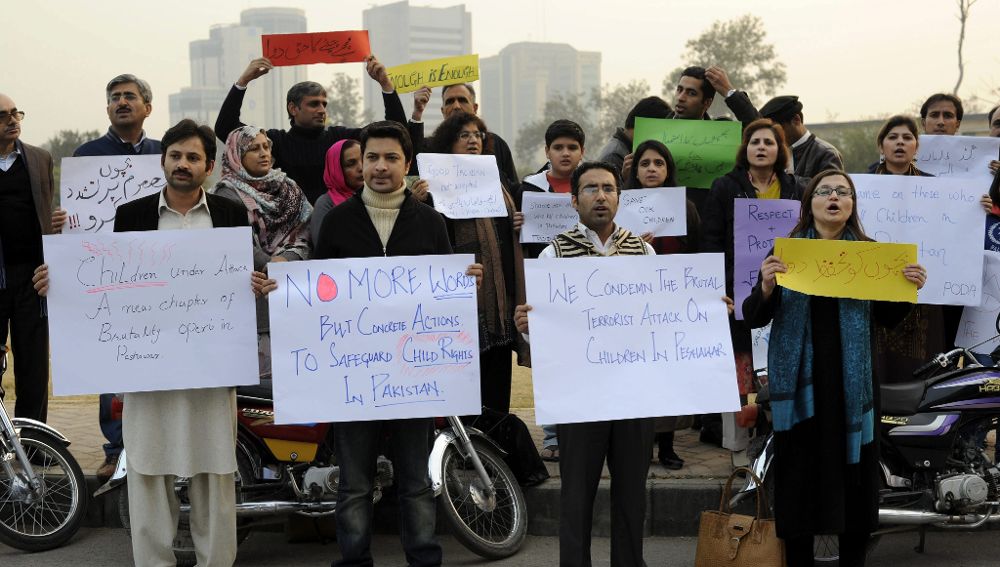 Varias personas muestran pancartas durante la protesta contra el ataque talibán contra un colegio gestionado por el Ejército en Peshawar, durante una manifestación en Islamabad, Pakistán.