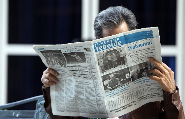 Un hombre lee el diario oficial cubano Juventud Rebelde.