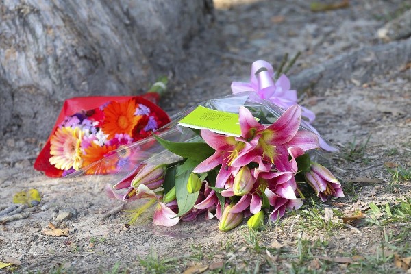 Ramos de flores son depositados ante la vivienda en la que se han encontrado ocho niños, de entre 18 meses y 15 años, asesinados a puñaladas en la localidad australiana de Cairns hoy, viernes 19 de diciembre de 2014.