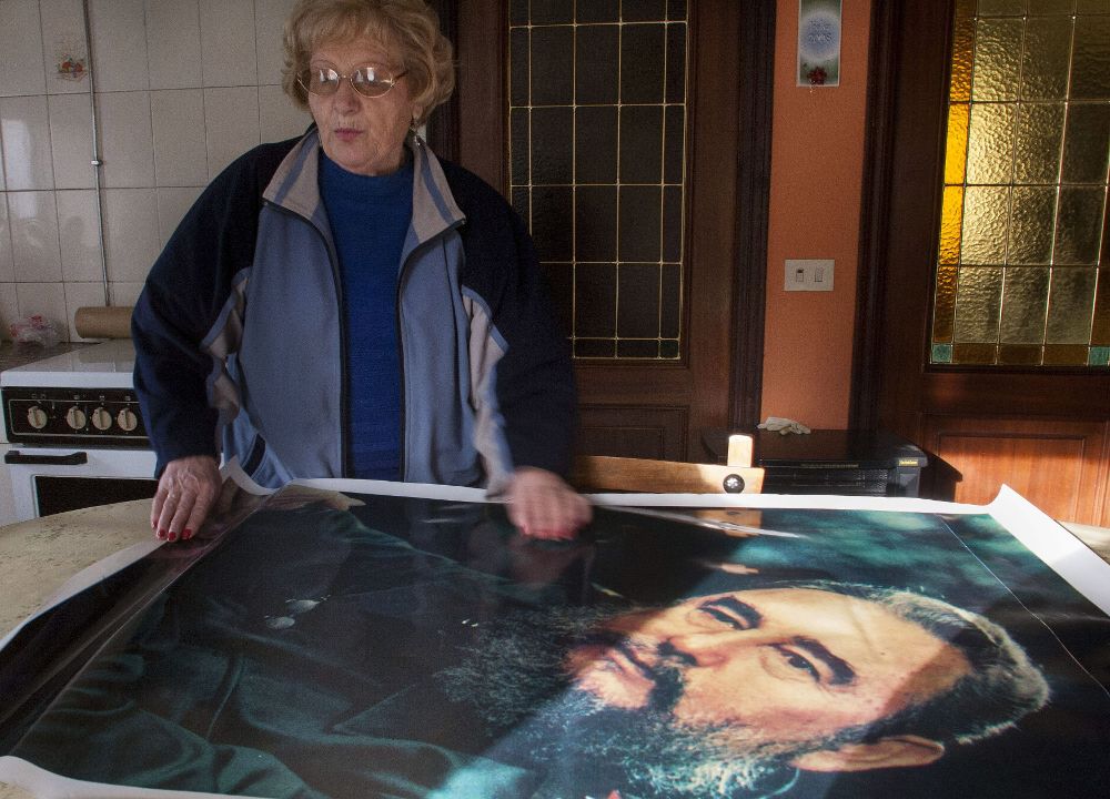 2008 de Victoria López Castro sosteniendo una foto de su primo, Fidel Castro, en su casa de Láncara.
