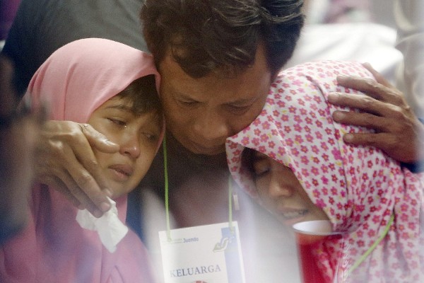Familiares lloran al ser informados de que han encontrado restos del avión desaparecido de AirAsia.