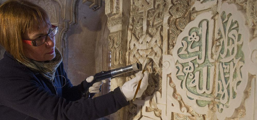 Una restauradora del taller de restauración de yesos y ceramicas de la Alhambra durante las labores de limpieza del techo de la Sala de dos hermanas de la Alhambra de Granada.
